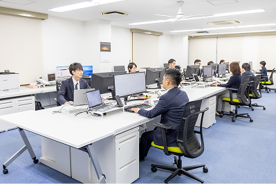 多くのスタッフが業務を行う、明るく広々とした執務スペース
